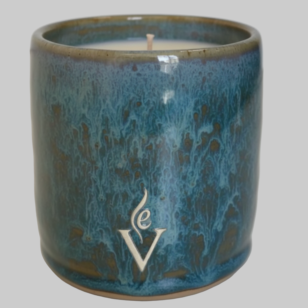 Blue ceramic candle holder with a logo on a white background