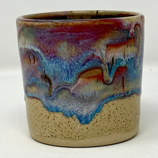 Ceramic candle jar with multicolored glaze on a white background