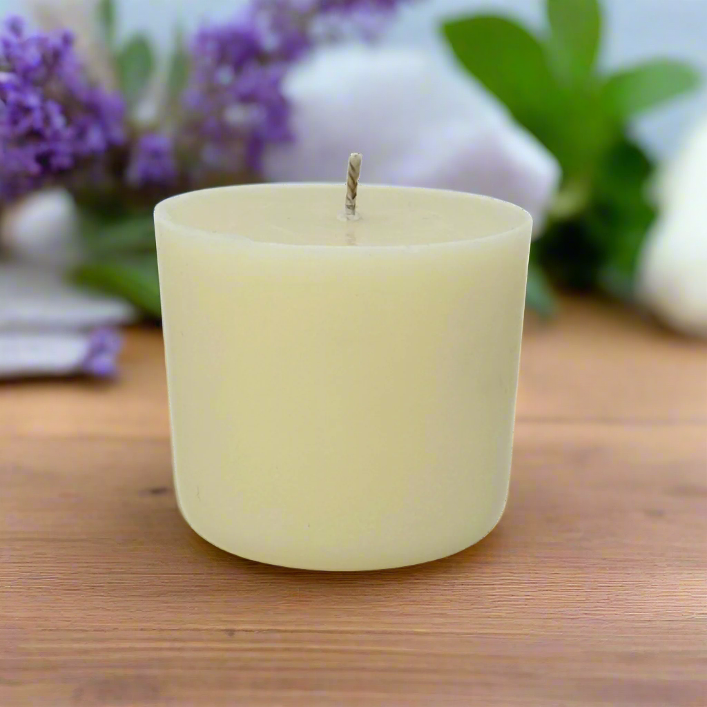 White candle refill on a wooden surface with blurred lavender flowers in the background