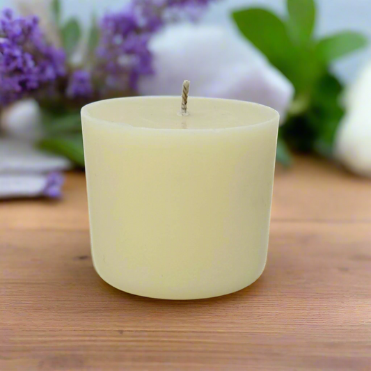 White candle refill on a wooden surface with blurred lavender flowers in the background