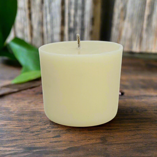 White essential oil candle refill  on a wooden surface with a blurred natural background