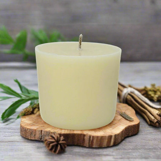 White candle refill on a wooden coaster with Geranium, Pine and Ylang Ylang in the background