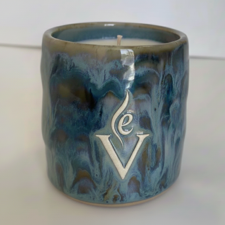 Blue ceramic candle holder with  logo on a white background