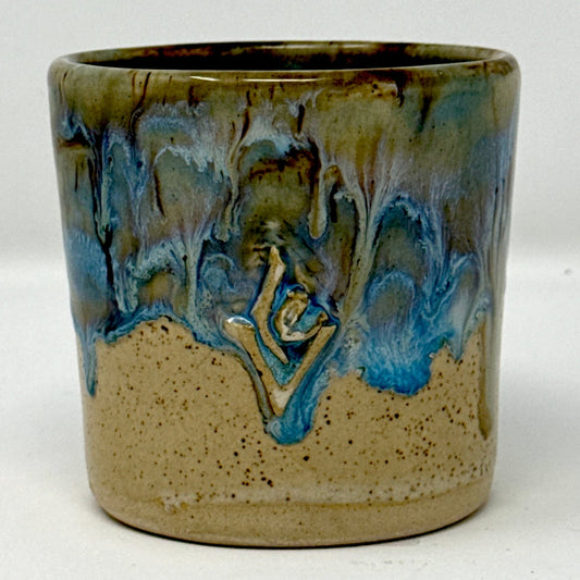 Ceramic cup with blue and green glaze on a white background